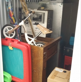 Storage unit full of children`s furniture and toys.