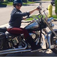 Urusla rides a motorcycle.