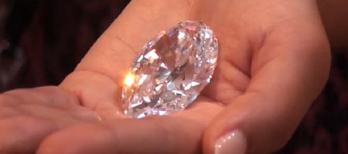 The Mouawad Splendour pear shape diamond held in hand.