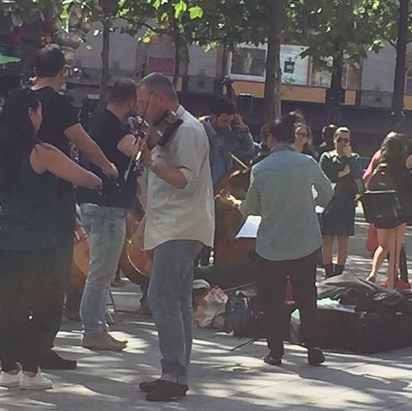 Musicians play on sidewalk.