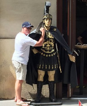 Roy Dirnbeck poses with statue of Roman soldier.