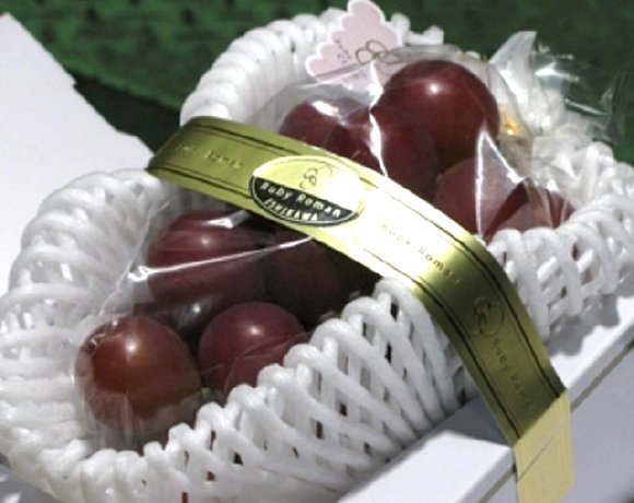 Small bunch of Ruby Roman Grapes in a box.