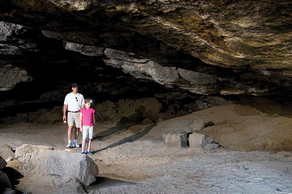 Man and young girl inside a cave.