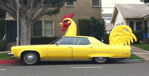 1970s Oldsmobile yellow designed with a big chicken head on hood and feather on trunk.