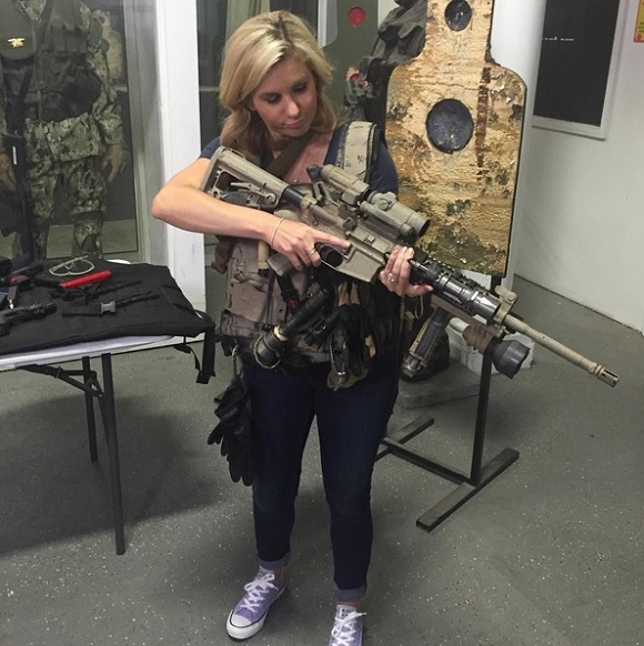 Brandi Passante in military gear with machine gun.