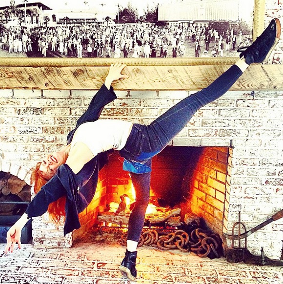 Candy Olsen dances next to fireplace. 