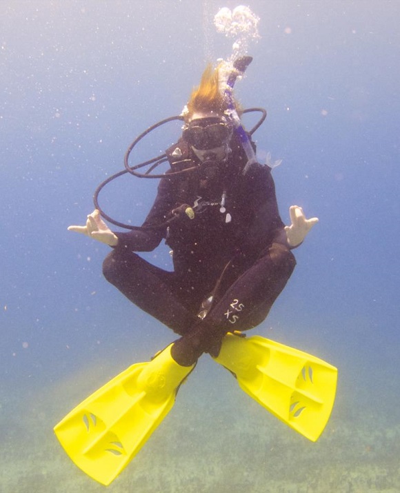 Candy Olsen scuba diver under water in mediation position.
