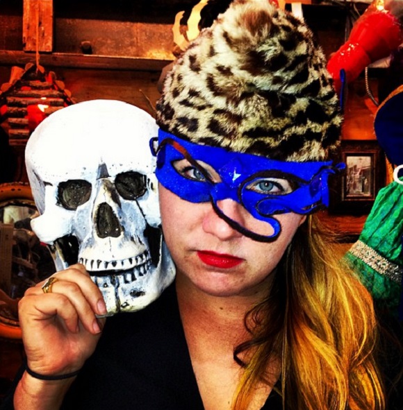 Courtney Wagner wears wears one mask and holds up a skeleton mask.